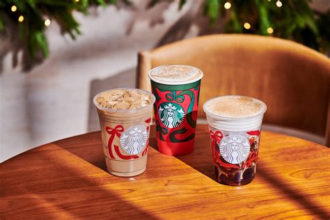 A Starbucks coffee cup featuring a seasonal drink next to a visible price tag.