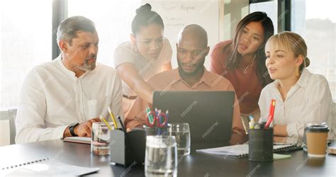 A team watching and analyzing examples of successful advertising campaigns on a laptop during a meeting.