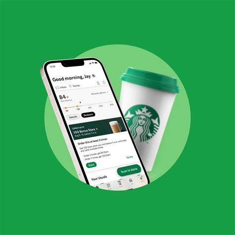 A smartphone displaying the Starbucks mobile app alongside a Starbucks coffee cup.