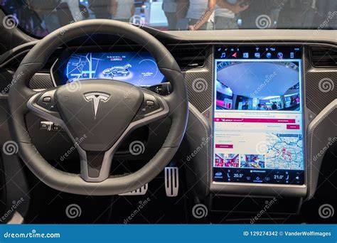 Close-up of a Tesla electric car's interior focusing on its advanced digital dashboard and controls.